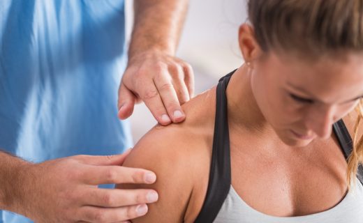 Physical therapy. Therapist addressing trapezius muscle